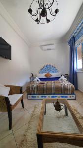 a bedroom with a bed and a mirror and a chandelier at Casa Familia in Chefchaouen