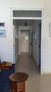 a hallway with a door and a table in a room at Casa Familia in Chefchaouen