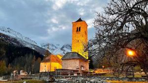 a large building with a clock tower on a mountain at Im Spiss in Macugnaga +39 photos
