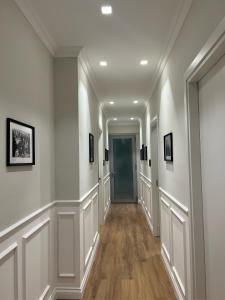 un couloir avec des murs blancs et une porte bleue dans l'établissement Cindy Rooms, à Termoli