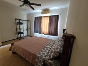 1 dormitorio con 1 cama y ventilador de techo en JFM Apartamento, en Coco