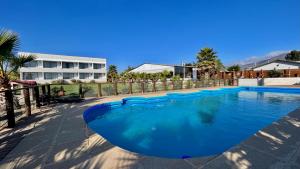 a large blue swimming pool in front of a building at Hotel Del Valle Quilimari in Pichidangui