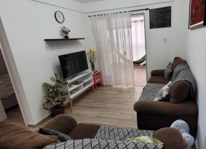 a living room with two couches and a flat screen tv at Apto praia pontal, vista mar in Rio de Janeiro