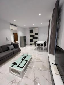 una sala de estar con un sofá y una mesa en Mumbas Apartment 2, en Himare