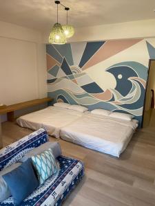 una camera con 2 letti, un divano e un murale di Lounge away a Città di Taitung
