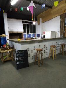 a kitchen with a counter and stools in a room at Sítio Gacied in Suzano