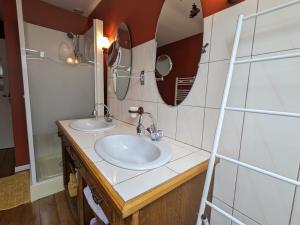 a bathroom with two sinks and a mirror at Gîte Lironcourt, 3 pièces, 5 personnes - FR-1-589-118 in Lironcourt