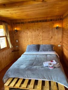 1 cama en una cabaña con pared de madera en La madriguera de Guatavita, en Guatavita