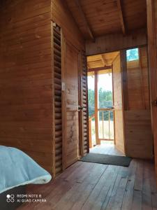 Pokój z drewnianymi ścianami, drewnianą podłogą i drzwiami w obiekcie La madriguera de Guatavita w mieście Guatavita