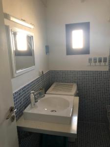 a bathroom with a sink and a mirror at Mini Villas Blue in Keratokampos