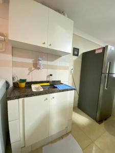 里約熱內盧的住宿－Apartamento no Recreio，厨房配有白色橱柜和冰箱。