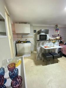 une petite cuisine avec une table et un four micro-ondes dans l'établissement Apartamento no Recreio, à Rio de Janeiro