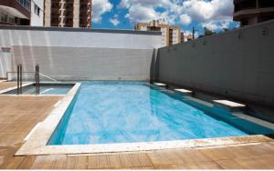 a large blue swimming pool on the side of a building at Apartamento tipo Flat para temporada em Caldas Novas com cozinha in Caldas Novas +24 photos