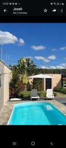 una piscina con 2 sillas y una casa en Casa Temporada Nosso Recanto Piscina aquecimento Solar, en Olímpia