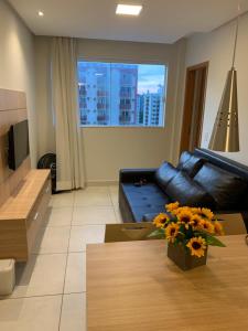 a living room with a couch and a table at Apartamento tipo Flat para temporada em Caldas Novas com cozinha completa in Caldas Novas