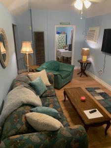 ein Wohnzimmer mit Sofa und Tisch in der Unterkunft Pink Flamingo at the Beach cottage in North Camellia Acres