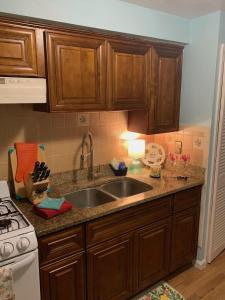 eine Küche mit Holzschränken und einer Spüle in der Unterkunft Pink Flamingo at the Beach cottage in North Camellia Acres