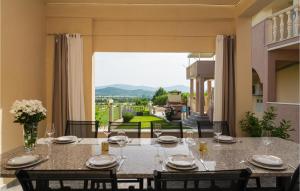 a dining room with a table and a large window at Beautiful Apartment In Obrovac Sinjski With Kitchen in Obrovac Sinjski