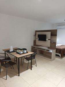 ein Wohnzimmer mit einem Tisch, Stühlen und einem TV in der Unterkunft Grace Apartaments in San Juan
