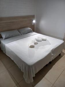 a bed with two towels and two pillows on it at Grace Apartaments in San Juan