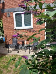 a table and chairs in front of a brick building at 32 Elder Drive Chester CH4 8PD in Chester