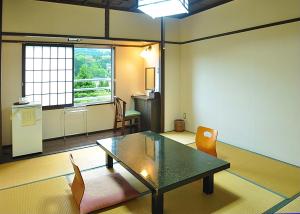 a room with a table and chairs and a window at Koyokaku in Ureshino