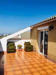 een patio met 2 stoelen op een huis bij Casa de Aurora in Rubí