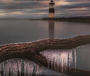 a lighthouse in the water with icicles on it at Home Away in Erie
