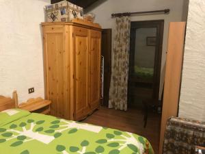 1 dormitorio con 1 cama y armario de madera en Im Spiss, en Macugnaga