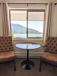 a table and two chairs in front of a window at Western Riviera Lakeside Lodging in Grand Lake