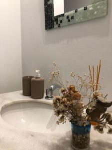 un lavabo con un jarrón con flores. en Amplia casa para 6 huéspedes en Mendoza en Godoy Cruz