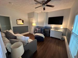 uma sala de estar com um sofá e uma televisão de ecrã plano em The Belvedere B&B em Charlevoix