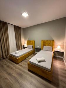 une chambre d'hôtel avec deux lits et une chambre avec dans l'établissement Bejart Apartment 4, à Tirana