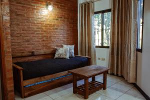 Ce lit se trouve dans une chambre dotée d'un mur en briques. dans l'établissement Wicz Apart Iguazú, à Puerto Iguazú