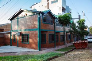een rood bakstenen gebouw met groene rand op een straat bij Cómodo Dúplex en Puerto Iguazú in Puerto Iguazú