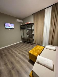 a living room with two beds and a tv at Bejart Apartment 4 in Tirana