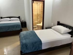 ein Schlafzimmer mit 2 Betten und ein Badezimmer mit einem WC in der Unterkunft Villa Thiago Finca in Armenia