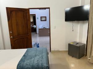 - une chambre avec un lit et une télévision à écran plat dans l'établissement Villa Thiago Finca, à Armenia