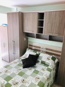 a bedroom with a bed and wooden cabinets at Pérola de Santos House in Santos