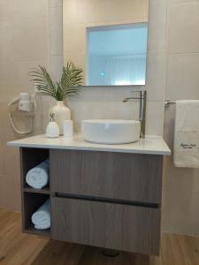 un bagno con lavandino e specchio di Lagoa azul guest house II a Vila Nova de Milfontes
