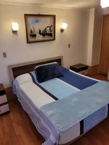 a large bed in a bedroom with a picture on the wall at Económicas y Cómodas Habitaciones Privadas cerca de Playa in Arica