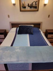 アリカにあるEconómicas y Cómodas Habitaciones Privadas cerca de Playaのベッドルーム1室(大型ベッド1台、青い掛け布団付)