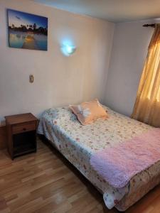 Habitación pequeña con cama y mesita de noche en Económicas y Cómodas Habitaciones Privadas cerca de Playa, en Arica