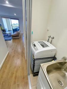 lavadero con lavadora y fregadero en Phillip Island Towers, en Cowes