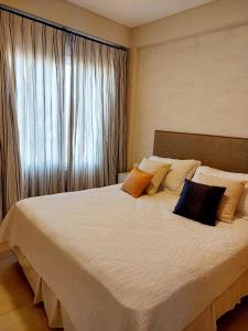 1 dormitorio con 1 cama blanca grande con almohadas en DEPARTAMENTO CENTRICO en Santa Rosa