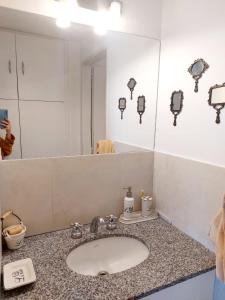 um balcão de casa de banho com um lavatório e um espelho em DEPARTAMENTO CENTRICO em Santa Rosa