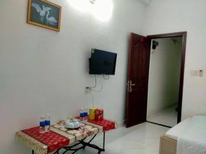 Zimmer mit einem Tisch und einem TV an der Wand in der Unterkunft Traveler’s choice home in Vietnam 1 in Củ Chi