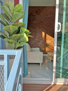 a living room with a couch and a plant at บ้านพักบุหงา199 แฟมิลี่ อ สรรพยา ชัยนาท in Ban Oi Noi (2) +36 photos