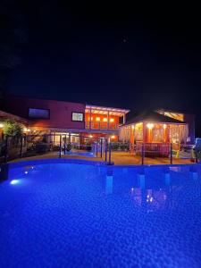 a large swimming pool in front of a building at night at Hotel Boutique Family Suites in Panguipulli