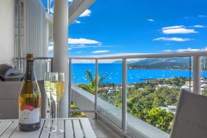 a bottle of wine sitting on a table with a view of the ocean at Serenity Views in Airlie Beach